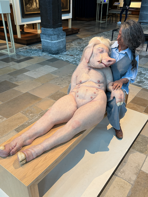 Came across this piece at the old hospital museum in Bruges—it’s called The Bridge by Patricia Piccinini. It shows a woman gently holding a strange human-animal hybrid. The artist is exploring the compassion of caring for others, ev