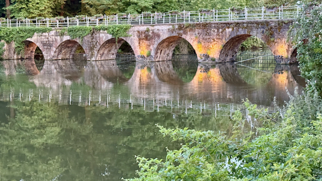 Evening light glowing through the arches of the Lover’s Bridge in Bruges—tranquility in every ripple.