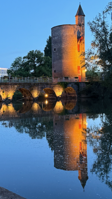 Poertoren standing guard over the canal—Bruges history shining through the twilight.