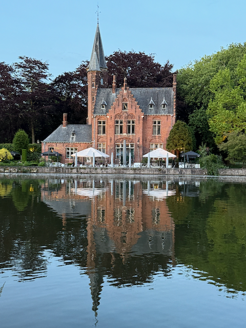 Reflections of a fairy tale—Chateau Minnewater glowing golden at twilight.